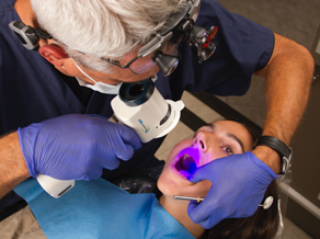 dentist using UV light on a patient's teeth